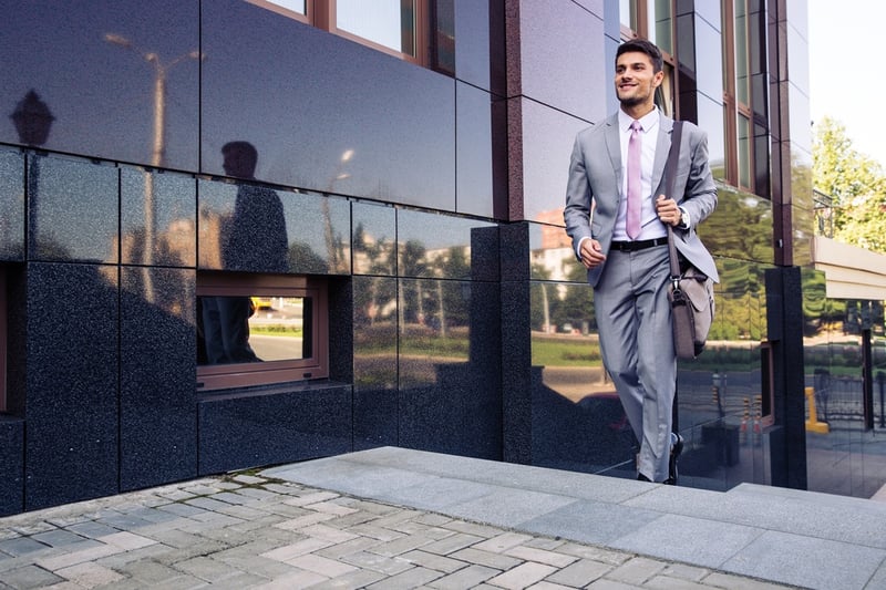 Happy businessman walking on stairs outdoors height legnthening success.jpeg