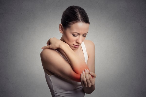 Joint inflammation indicated with red spot on female's elbow. Arm pain and injury concept. Closeup portrait woman with painful elbow on gray background .jpeg