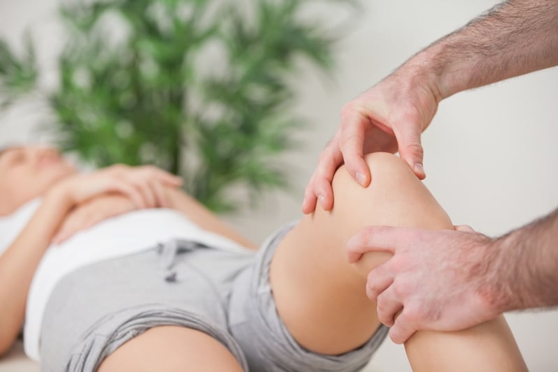 Practitioner using his fingers to massage a knee in a room.jpeg