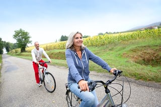Senior couple riding bicycle in countryside.jpeg