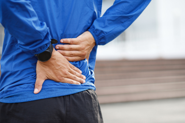 closeup man holding lower back in pain